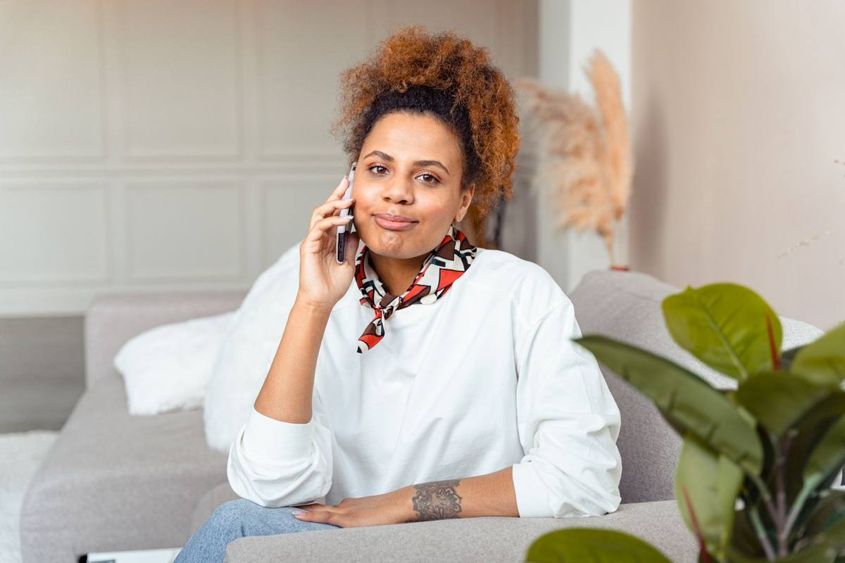 Vrouw belt ontspannen vanaf de bank (tijdelijke stockfoto, Pexels 7579177)